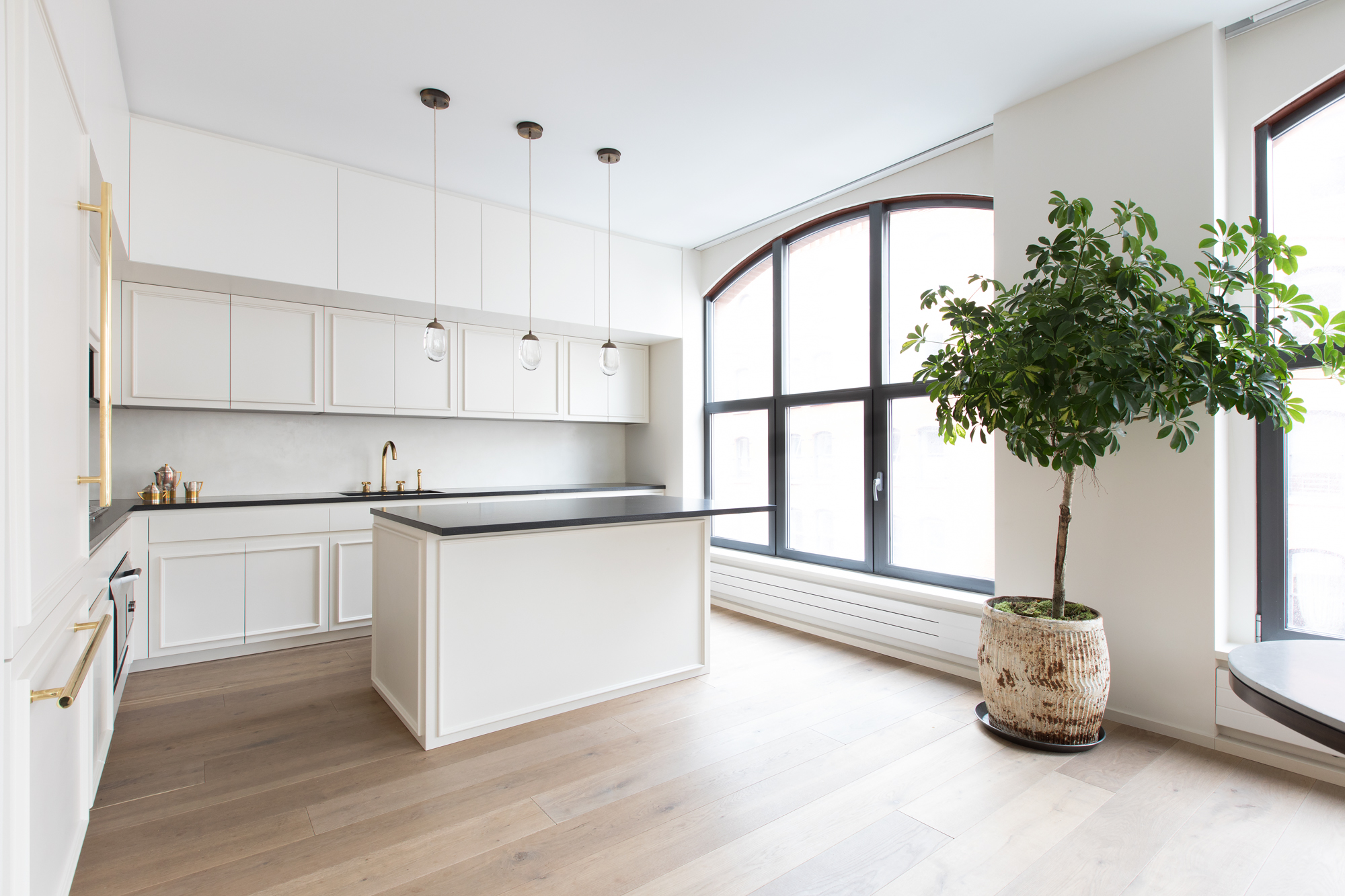 Portofino kitchen — handle-free elegance with brass fixtures and island seating